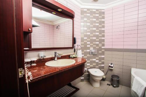 ein Badezimmer mit einem Waschbecken, einem WC und einem Spiegel in der Unterkunft Marma Hotel Istanbul Asia in Istanbul