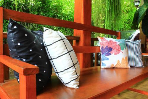 a wooden bench with pillows sitting on it at Oemah Kajoe Lembang in Lembang