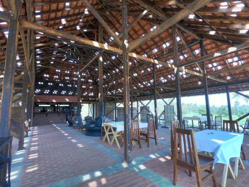 ein großes Holzgebäude mit Tischen und Stühlen in der Unterkunft SpiceTree Chinnar in Dhali