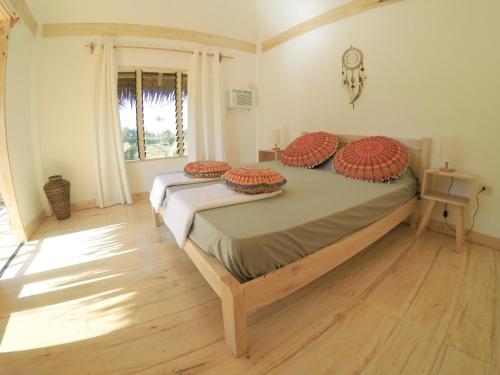 Un dormitorio con una cama con almohadas rojas. en Mandala Tribe Treehouses, en Siquijor