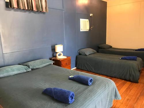 a room with two beds with blue pillows on them at Wagon Wheel Motel in Cloncurry