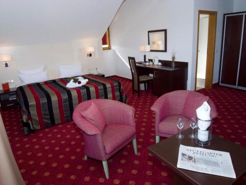 a hotel room with a bed and two chairs and a table at Hotel Empfinger Hof, Sure Hotel Collection by Best Western in Empfingen