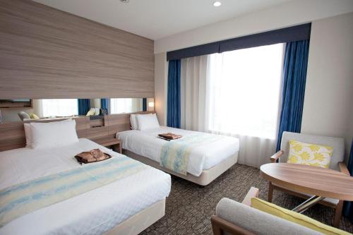 A bed or beds in a room at Almont Hotel Naha Kenchomae