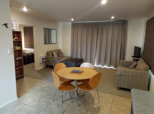 a living room with a table and chairs at Patons Rock Beach Villas in Takaka