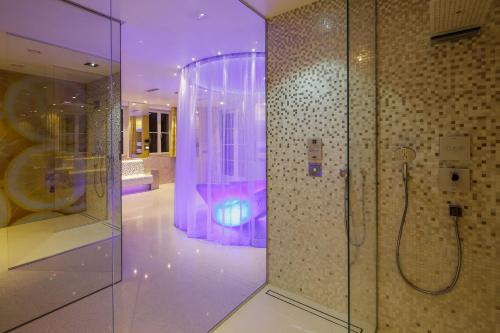 a bath room with a shower and a tub at Hotel Lemongarden - Adults Only in Sutivan