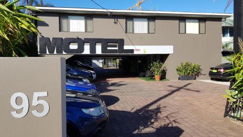 a motel with cars parked in front of a building at Gold Coast Airport Motel - Only 300 Meters To Airport Terminal in Gold Coast