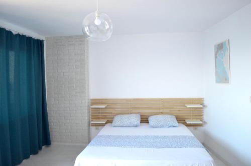 1 dormitorio con 1 cama y cortina verde en Deep Blue Guest House, en Sozopol