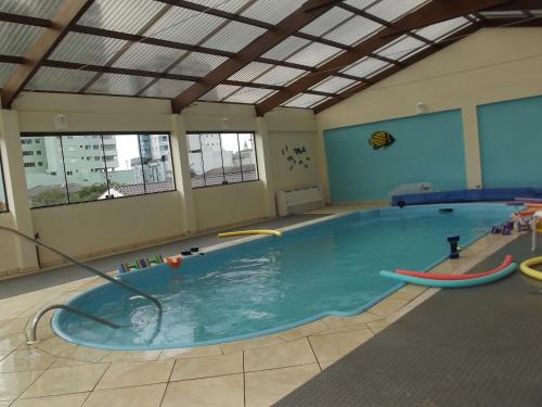 a large swimming pool with a pool noodle in it at Hotel Mares do Sul in Tramandaí