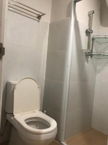 a white bathroom with a toilet and a shower at Nagoya Mansion Apartment Batam in Nagoya