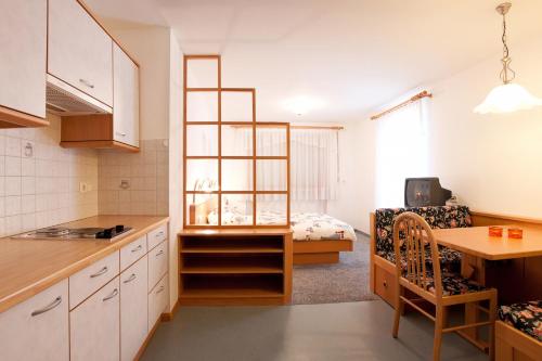 eine Küche und ein Wohnzimmer mit einem Bett in einem Zimmer in der Unterkunft Appartement Thanei in Burgeis