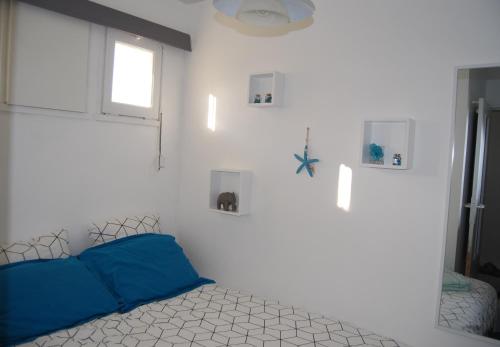 アルカションにあるT1Bis centre d'Arcachon avec balconのベッドルーム1室(青い枕のベッド1台、窓付)