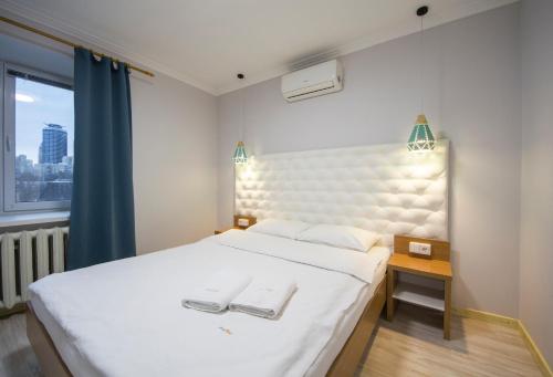 a bedroom with a white bed with two towels on it at Central Dayflat Apartments in Kyiv