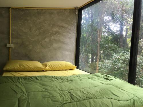 a bed in a room with a large window at BeachBox@Koh Сhang in Ko Chang
