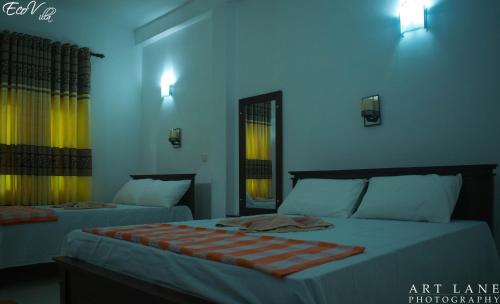 two beds in a room with blue walls at Eco Villa - Sinharaja in Deniyaya