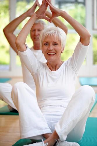 an older woman sitting in a yoga pose with her husband at Vivea Gesundheitshotel Bad Häring in Bad Häring