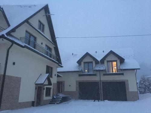 a house with snow on the windows of it at Silver Residence in Rabka