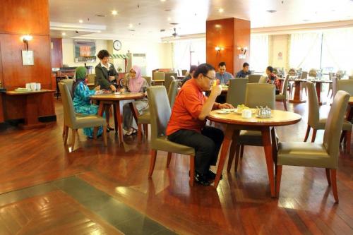 a group of people sitting at tables in a restaurant at Good Hope Hotel in Skudai