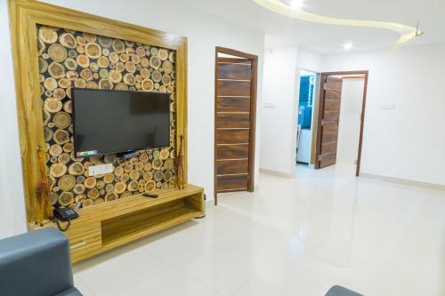 a living room with a flat screen tv on a wall at The Porch Inn Hotel/Service Apartments in Bengaluru