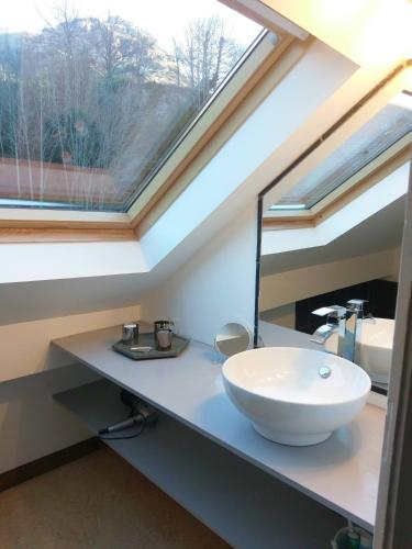 une salle de bain avec un lavabo et un miroir dans l'établissement Résidence du Parc avec Sauna, à Eaux-Bonnes