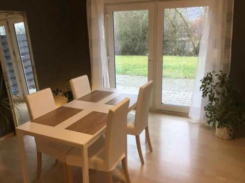 einen Holztisch und Stühle in einem Zimmer mit Fenster in der Unterkunft Ferienwohnungen zum Hirschberg in Sankt Wendel