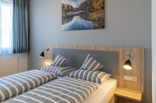 2 Betten in einem Schlafzimmer mit einem Bild an der Wand in der Unterkunft Hotel Lumi in Freiburg im Breisgau