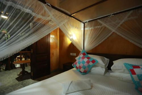 a bedroom with a bed with a canopy at Limecabanas-srilanka in Galle