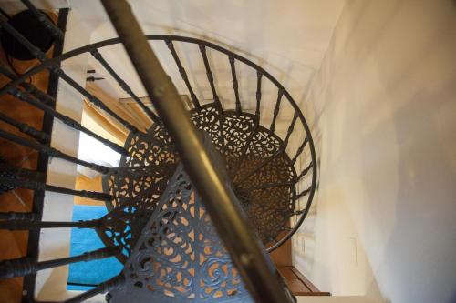 a stairway with a metal railing and a black and white checkered at Hotel Locanda Degli Artisti in Borgo San Lorenzo
