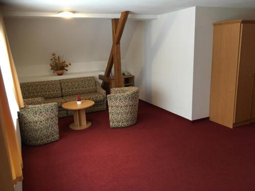 a living room with a couch and a table at Hainberg Hotel Garni in Habrachćicy