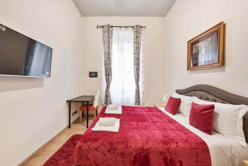 een slaapkamer met een groot bed en een rode deken bij Via Umberto in Rome