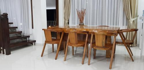 a wooden dining table and chairs in a room at Grace Hill Villa Lubuk Minturun in Padang