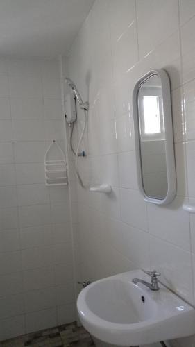 a bathroom with a sink and a shower with a mirror at Kathleens Vacation Place in Moalboal