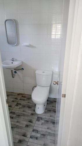 a white bathroom with a toilet and a sink at Kathleens Vacation Place in Moalboal