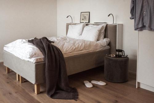 a bedroom with a bed with a blanket on it at Bob W Koti Ullanlinna in Helsinki