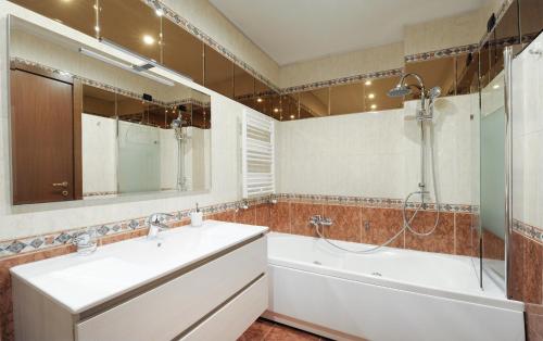 bagno con vasca, lavandino e doccia di In+out Sempione Park Apartment a Milano