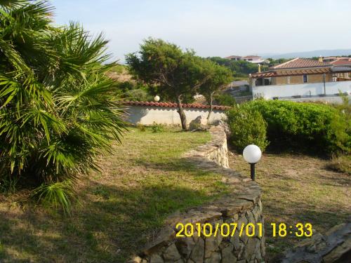 a stone wall next to a yard with trees at ZIRICHELTULA Villa PANORAMICA con ARIA CONDIZIONATA in Lu Pultiddolu