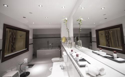 a bathroom with two sinks and a bath tub at Hotel Maria Theresia in Mayrhofen