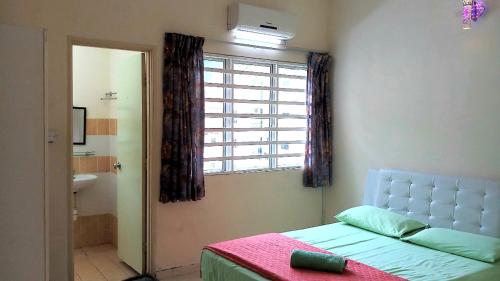 a bedroom with a bed and a window and a bathroom at Jeffrey Homestay B @ Lost World of Tambun in Ipoh