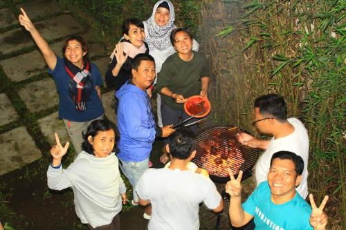 a group of people standing around a grill at Oemah Kajoe Lembang in Lembang