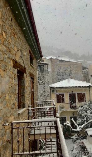 a snow covered balcony of a house with a snow covered yard at Konaki Tselepi in Arachova