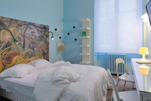 Schlafzimmer mit einem Bett mit Wandgemälde in der Unterkunft HOTEL CONTINENTAL in Saint-Étienne