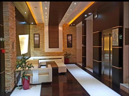 un vestíbulo con sofá y mesas en un edificio en Apartment 111 at Zoned Apart Hotel & Spa - Apartman 111 u hotelu Zoned, en Kopaonik