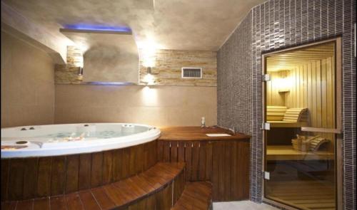 a large bathroom with a large tub and a bedroom at Apartment 111 at Zoned Apart Hotel & Spa - Apartman 111 u hotelu Zoned in Kopaonik