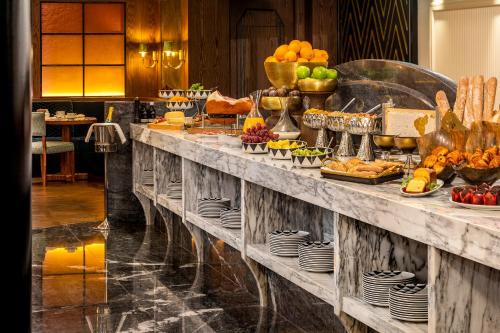 Una línea de buffet con muchos tipos diferentes de comida. en The One Monumental Palace, en Oporto
