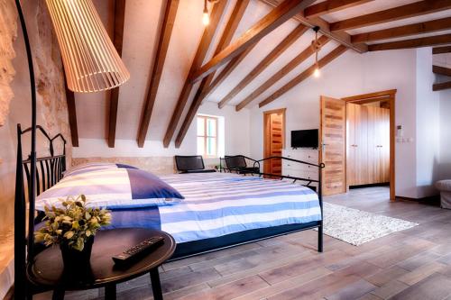 a bedroom with a bed in a room with wooden ceilings at Stone Villa Lemon with pool in Vis in Vis