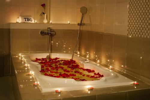 a bath tub filled with lots of red roses at ALSHIFA TBG RESIDENCY in Perintalmanna