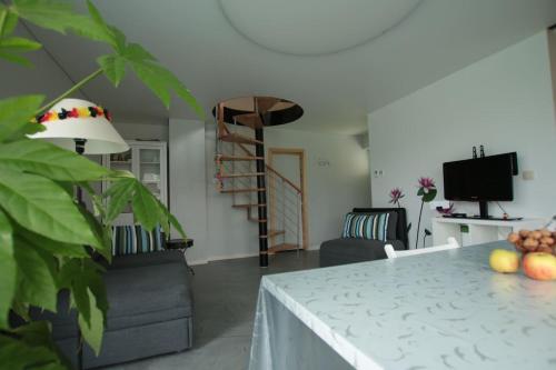een woonkamer met een tafel en een televisie bij Studio confortable à la campagne et proche de la ville in Walhain-Saint-Paul