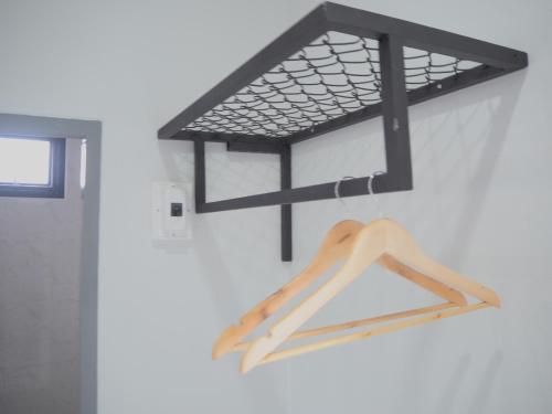 a wooden hanger hanging on a wall at บ้านรวมสุข the Happiness in Chiang Kham