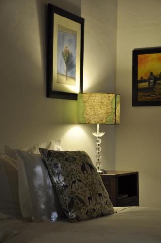 a bedroom with a bed with a pillow and two lamps at Wildekrans Country House in Botrivier