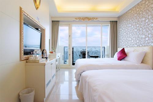 a hotel room with two beds and a large window at Starrise Leisure Hotel in Dahan
