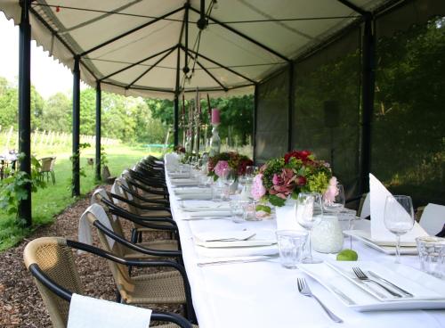 a long table in a marquee with white tables and chairs at Fletcher Hotel-Restaurant De Klepperman in Hoevelaken